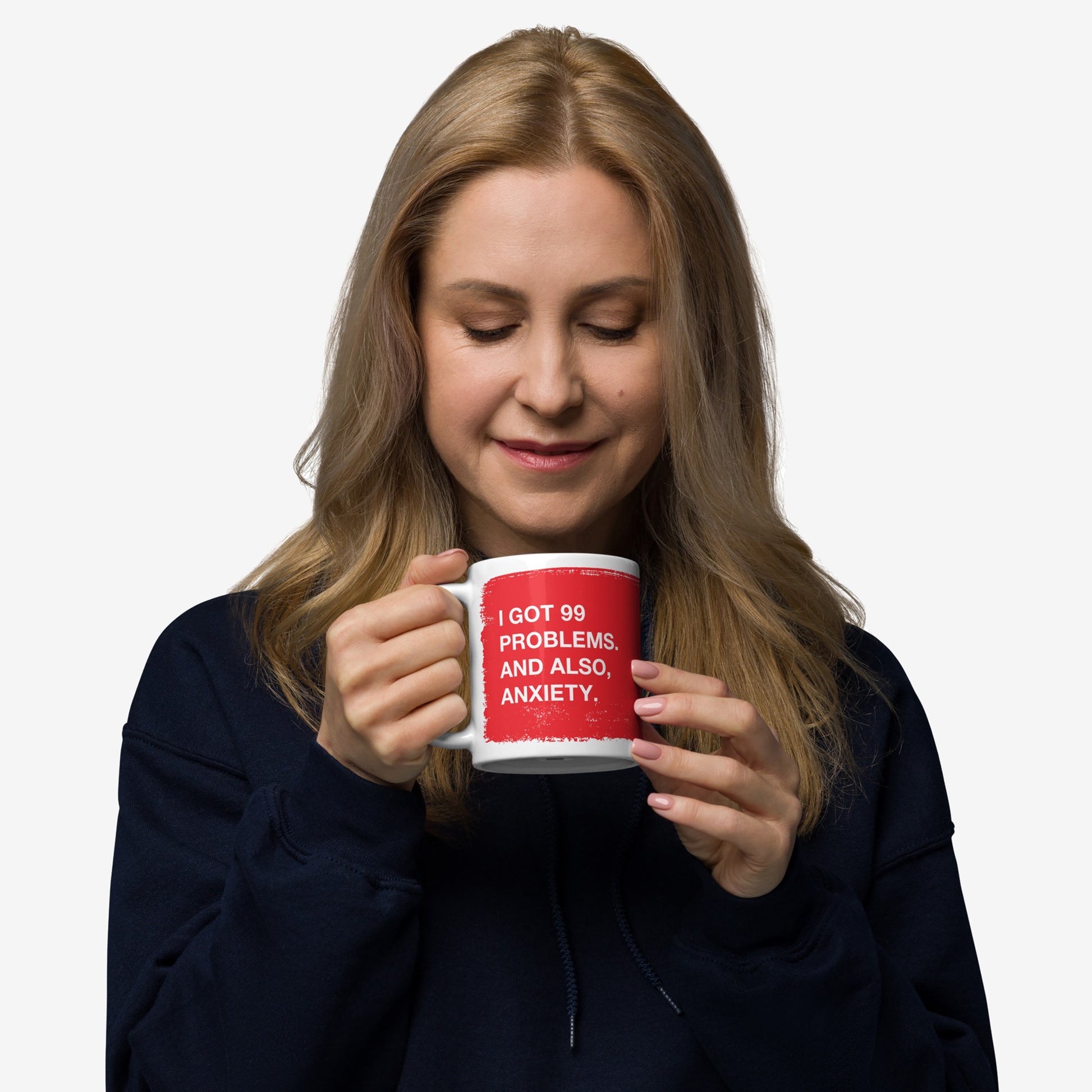 Woman holding and smiling at a 99 Problems Mug with the text about anxiety on a red background.