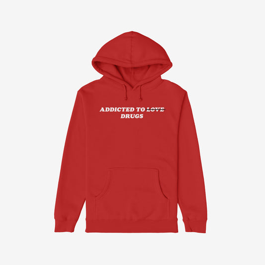 The Egoproof Addicted To Love / Drugs Hoodie is a bold red hoodie with ADDICTED TO ~LOVE~ DRUGS on the front—perfect for fans of dark humor. Part of each purchase supports NAMI through donation initiatives.