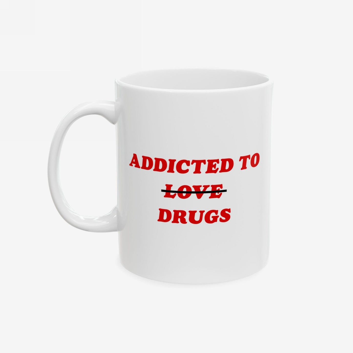 White ceramic mug featuring Addicted To Love / Drugs with LOVE crossed out for DRUGS in bold red, embodying dark humor and mental health themes. Available in two sizes, 11 oz and 15 oz.