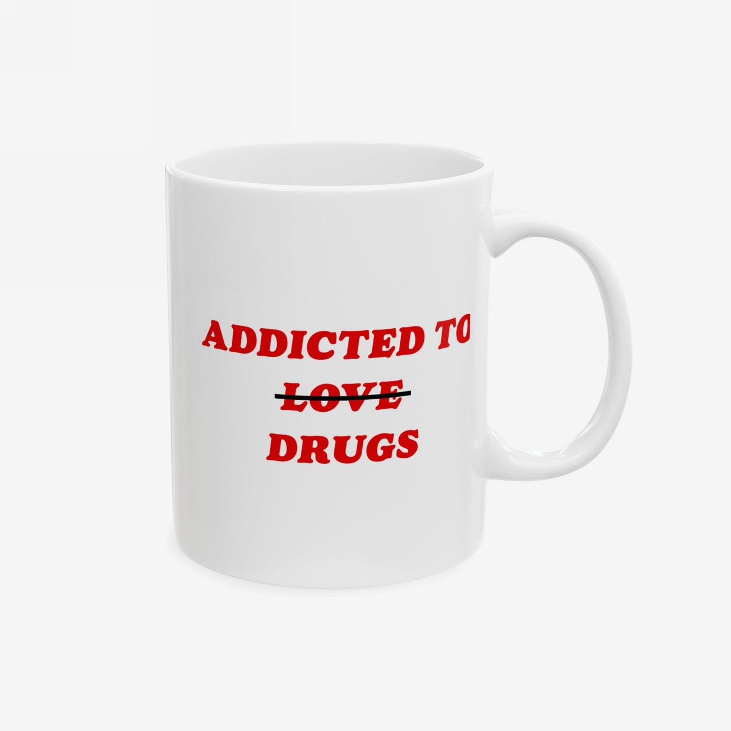 The Addicted To Love / Drugs Mug features a white ceramic design with ADDICTED TO ~~LOVE~~ DRUGS in red, where LOVE is humorously crossed out, symbolizing a witty take on coping mechanisms.
