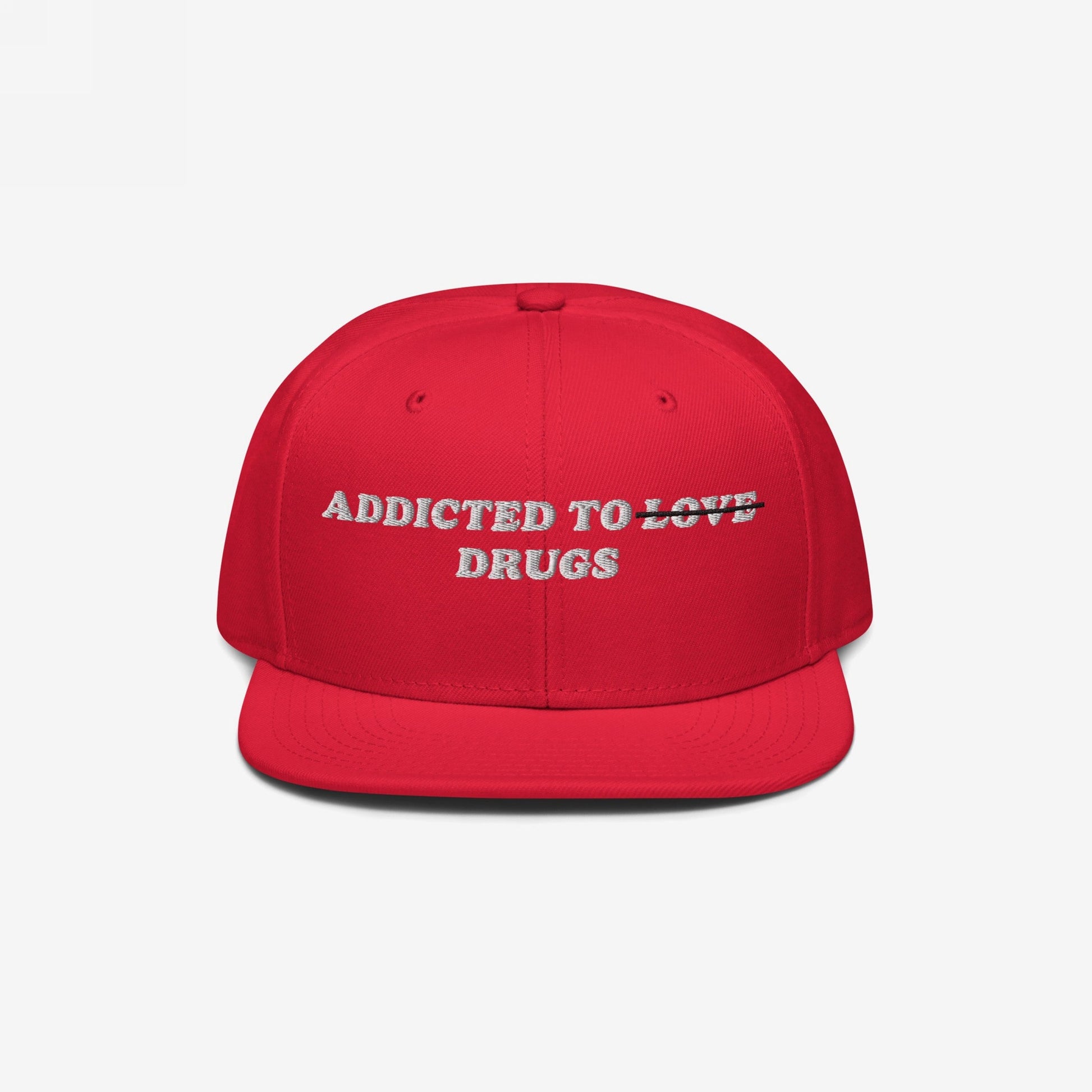 The Egoproof Addicted To Love / Drugs Hat is a bold red embroidered snapback featuring playful text—LOVE struck through and replaced by DRUGS—set against a crisp white background for a striking mental health statement.