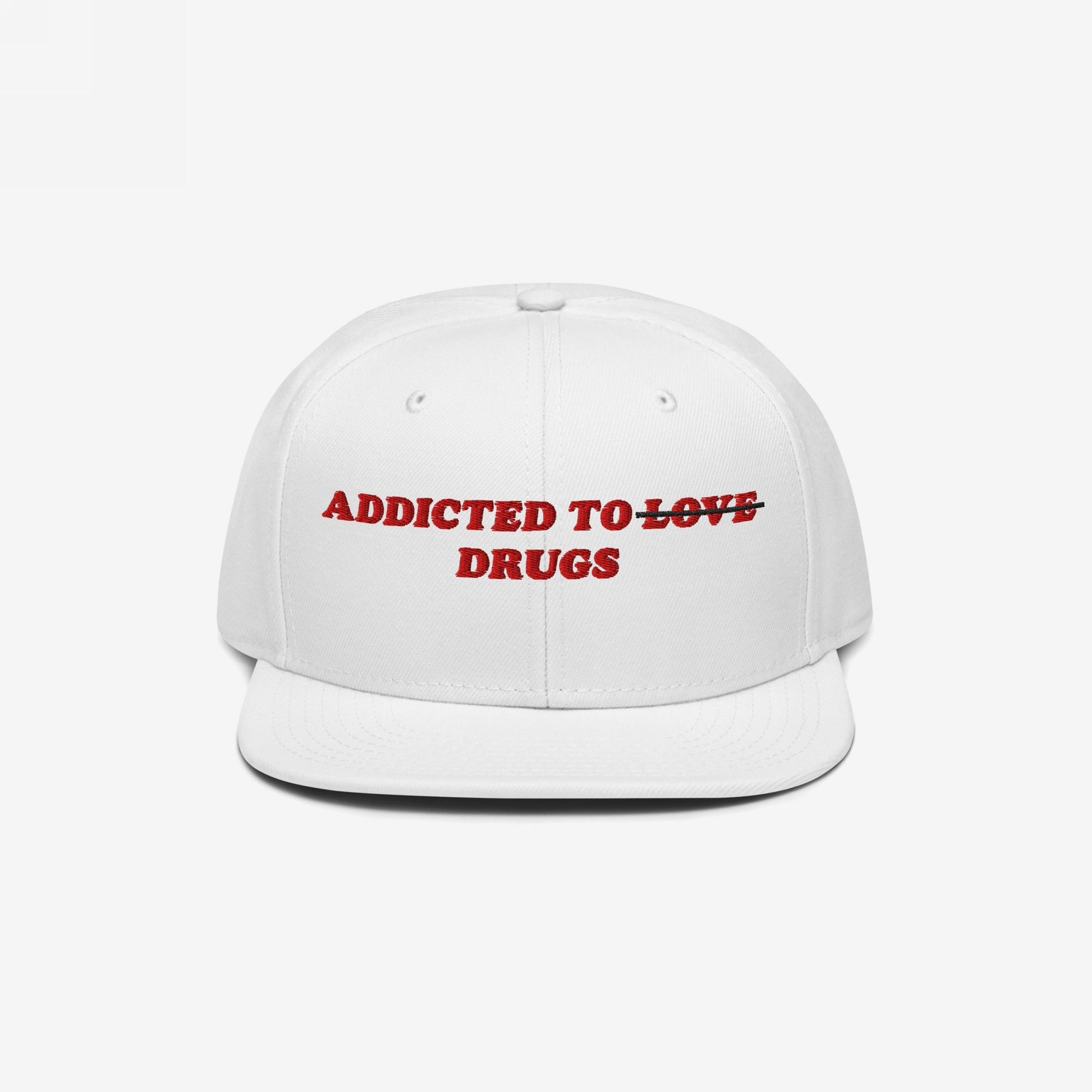 The Egoproof Addicted To Love / Drugs Hat is a white snapback with bold embroidery, featuring “LOVE” crossed out and replaced by “DRUGS” in red, making a powerful mental health statement.