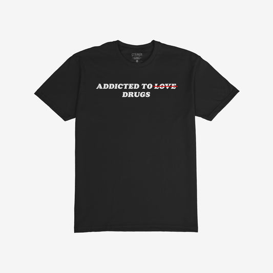 Black unisex Addicted To Love / Drugs T-shirt with bold white text crossing out love and highlighting drugs.