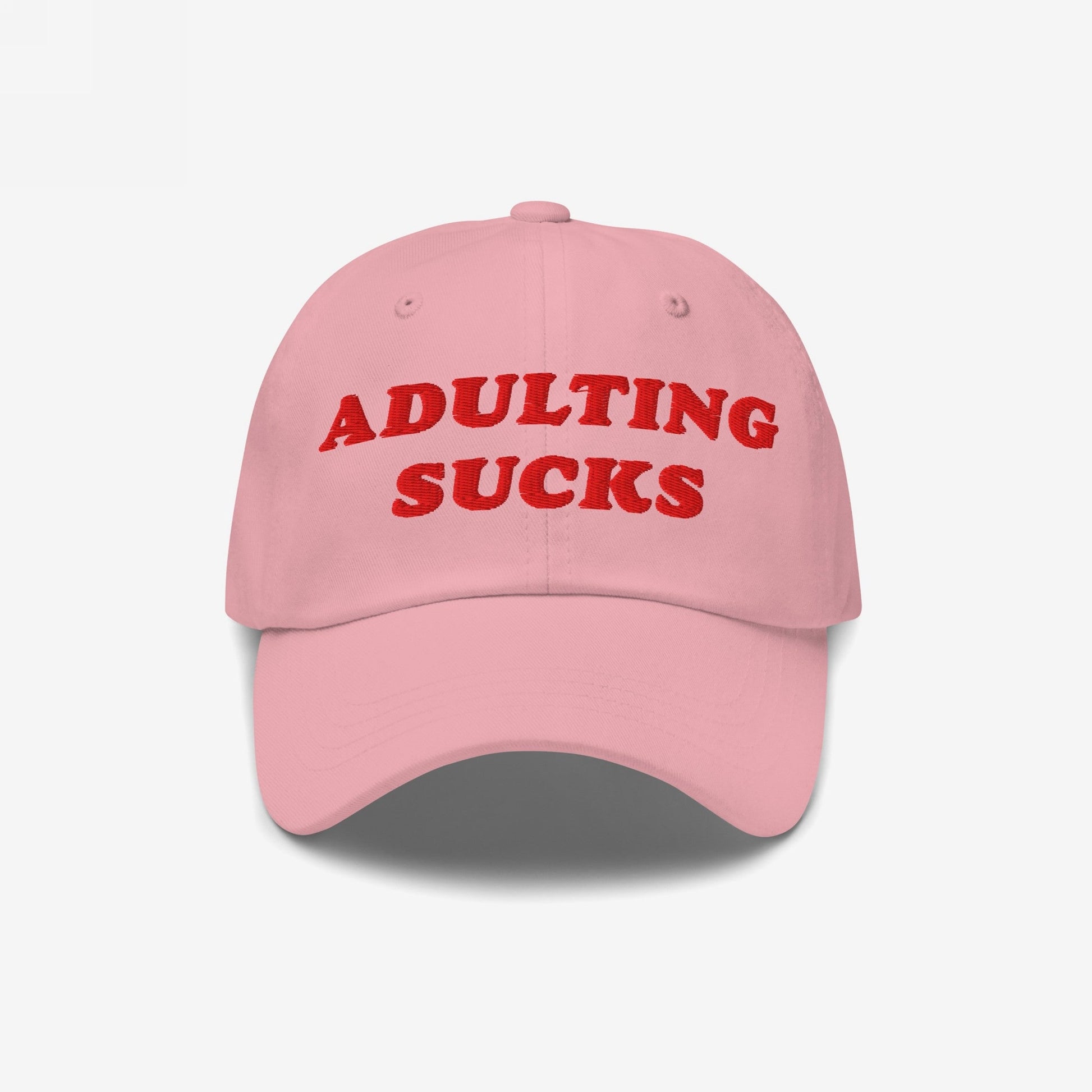 Light pink cap with bold red embroidery stating ADULTING SUCKS on the front, reflecting Egoproof's ethos. A vintage-inspired, relatable piece for those facing life's pressures.