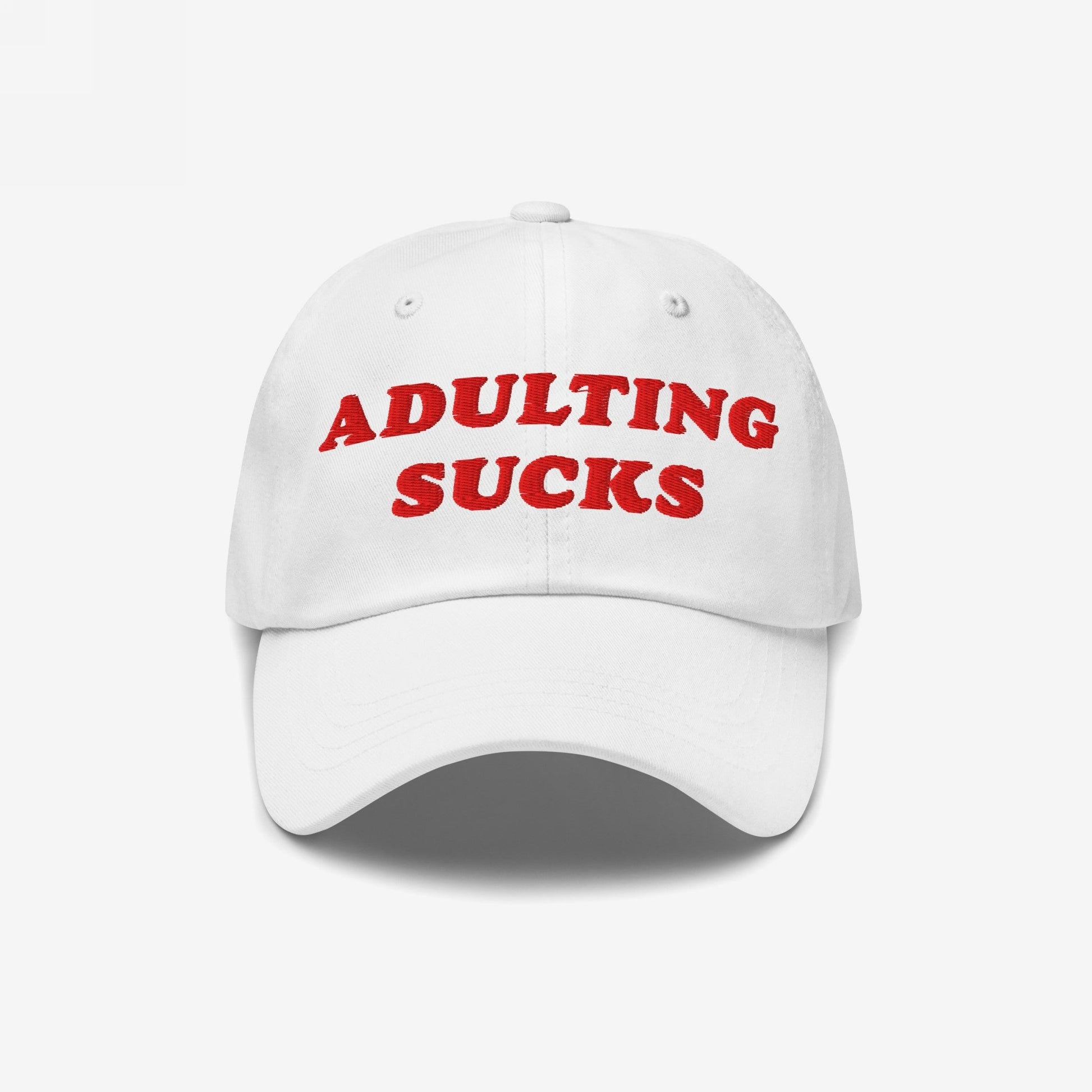 The Adulting Sucks Hat features bold red embroidery stating ADULTING SUCKS on a white baseball-style cap, embodying a vintage, honest vibe perfect for those overwhelmed by life’s demands.