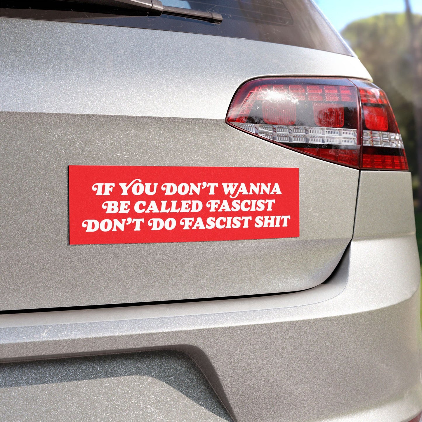 Anti-Fascist Sticker & Magnet on a silver car's bumper, featuring bold white text urging resistance against fascism. Designed for those who reject hate and oppression, offering durable, weather-resistant quality.