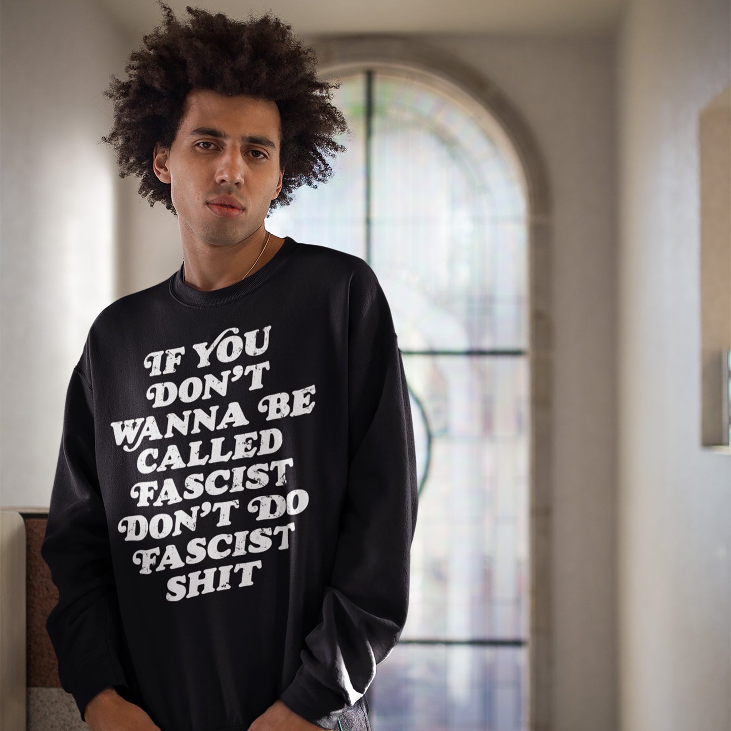 Young person in black sweatshirt with bold message: If you don’t wanna be called fascist don’t do fascist shit, showcasing the Anti-Fascist Hoodie & Sweatshirt from Egoproof.