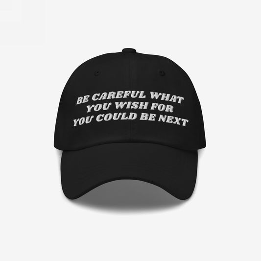Black six-panel Be Careful Hat with a curved brim, featuring bold off-white embroidery: “BE CAREFUL WHAT YOU WISH FOR YOU COULD BE NEXT.” Ideal for making a strong, unapologetic statement.