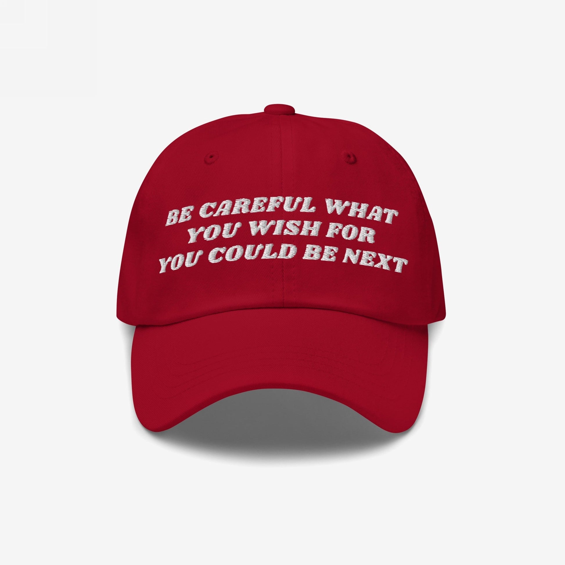 Red baseball-style cap featuring white embroidered text: BE CAREFUL WHAT YOU WISH FOR YOU COULD BE NEXT. The Be Careful Hat embodies bold expression, ideal for progressive, socially-conscious wearers.