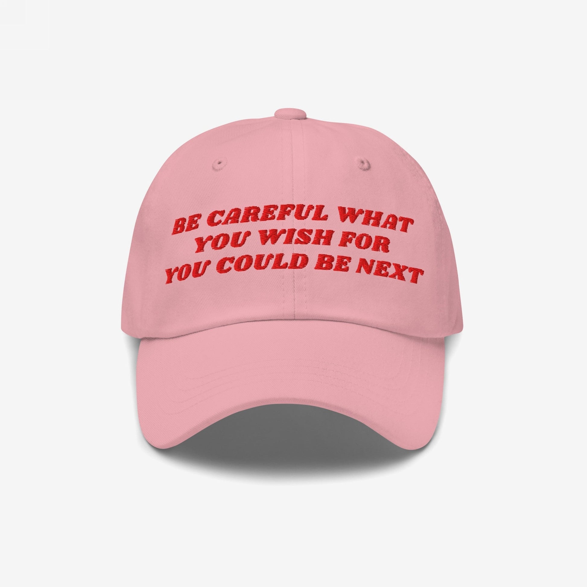 Be Careful Hat featuring red embroidered text 'BE CAREFUL WHAT YOU WISH FOR YOU COULD BE NEXT' on a pink baseball cap, embodying bold, unapologetic expression for progressive minds.