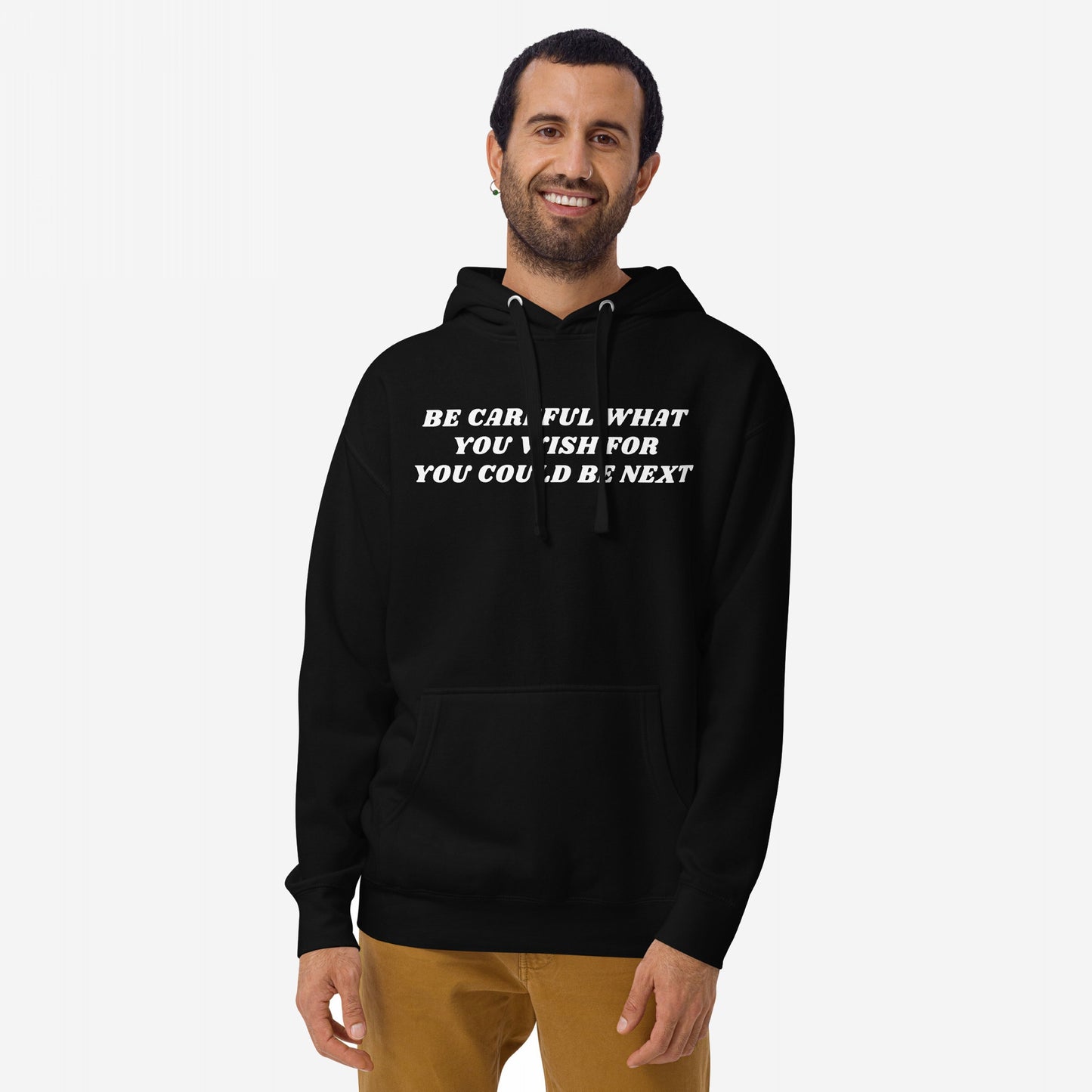 Man wearing Be Careful Hoodie EU with bold message, standing relaxed. Hoodie promotes activism and rebellion, designed for those challenging norms.