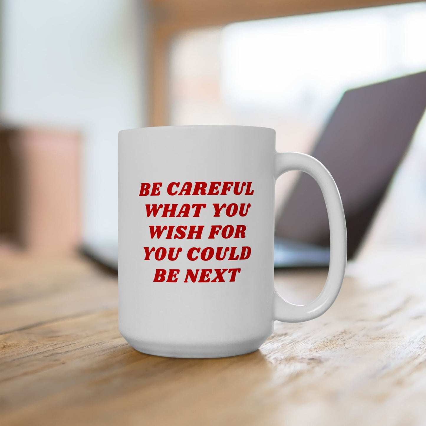 Be Careful Mug on a wooden desk, featuring a bold red warning message. Perfect for the politically awake and socially exhausted, this ceramic mug fuels realism with every sip.