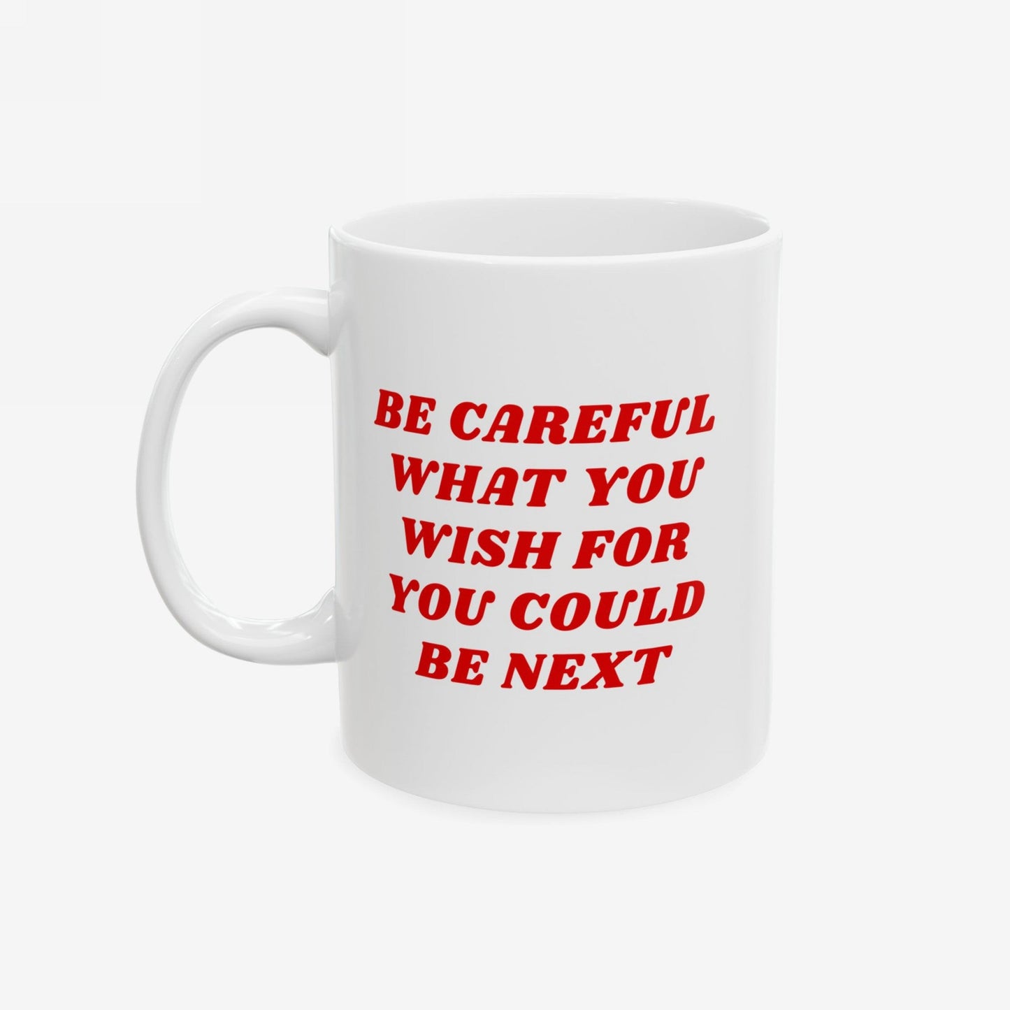 A white ceramic Be Careful Mug with bold red text, BE CAREFUL WHAT YOU WISH FOR YOU COULD BE NEXT, designed for the politically aware, featuring a standard C-handle.