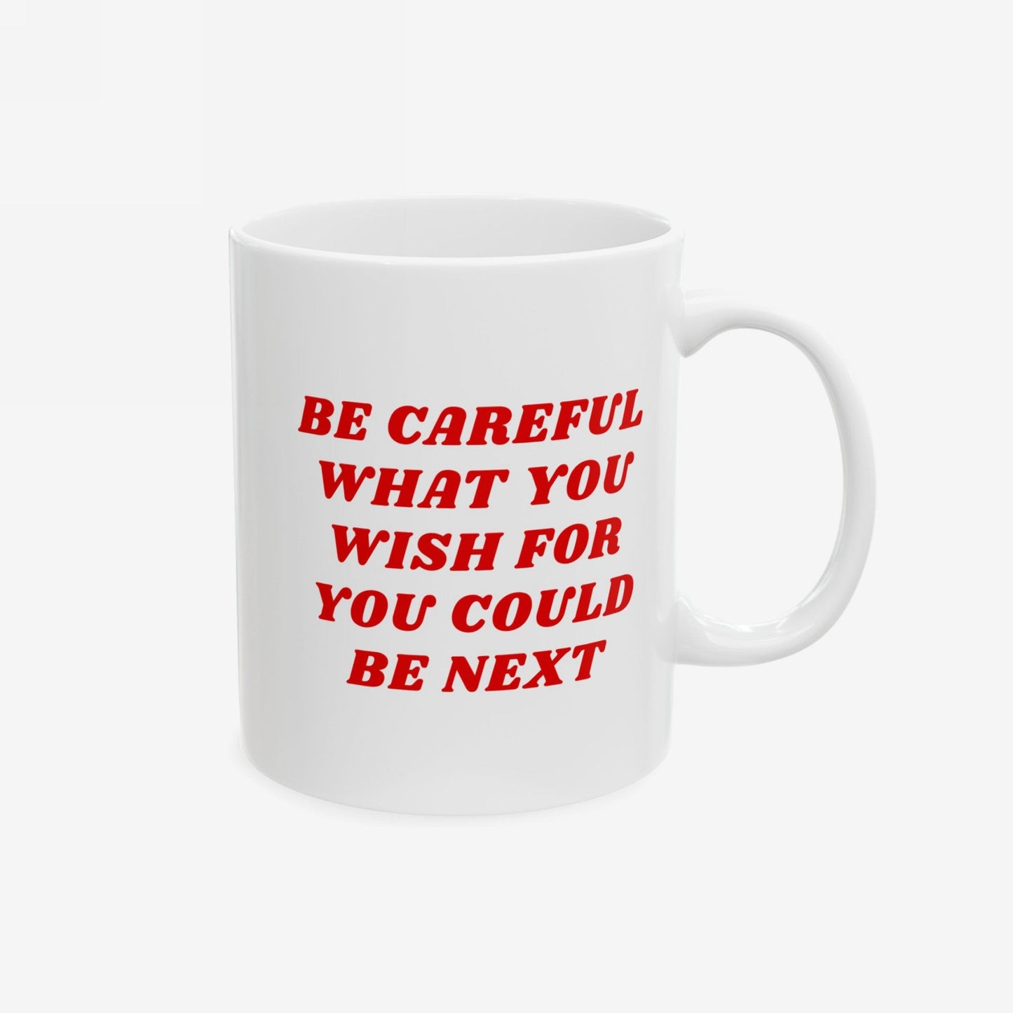 A white ceramic Be Careful Mug with bold red text reading BE CAREFUL WHAT YOU WISH FOR YOU COULD BE NEXT, designed for the politically aware, featuring a standard C-handle.