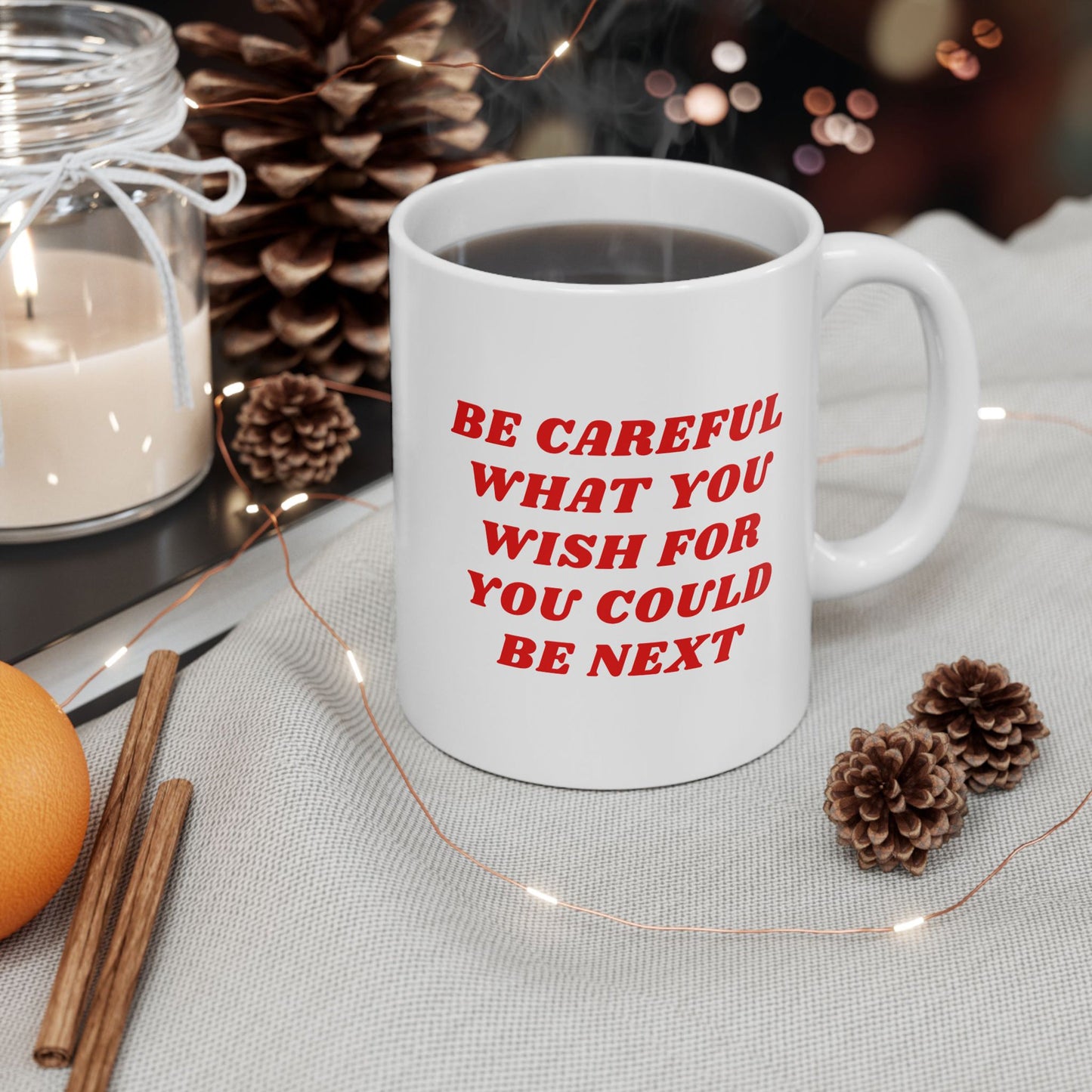 Be Careful Mug in a cozy holiday setting, surrounded by fairy lights, pine cones, and a candle. Features bold red text for the socially conscious, blending humor with a seasonal touch.