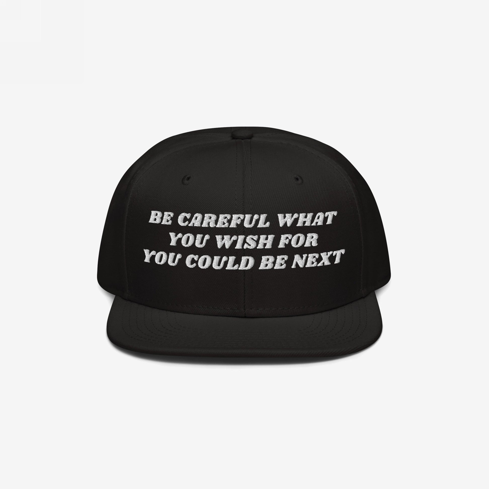 Black flat-brim snapback cap with bold white embroidery stating, Be Careful What You Wish For, You Could Be Next. The Be Careful Hat embodies bold, unapologetic expression against extremism.
