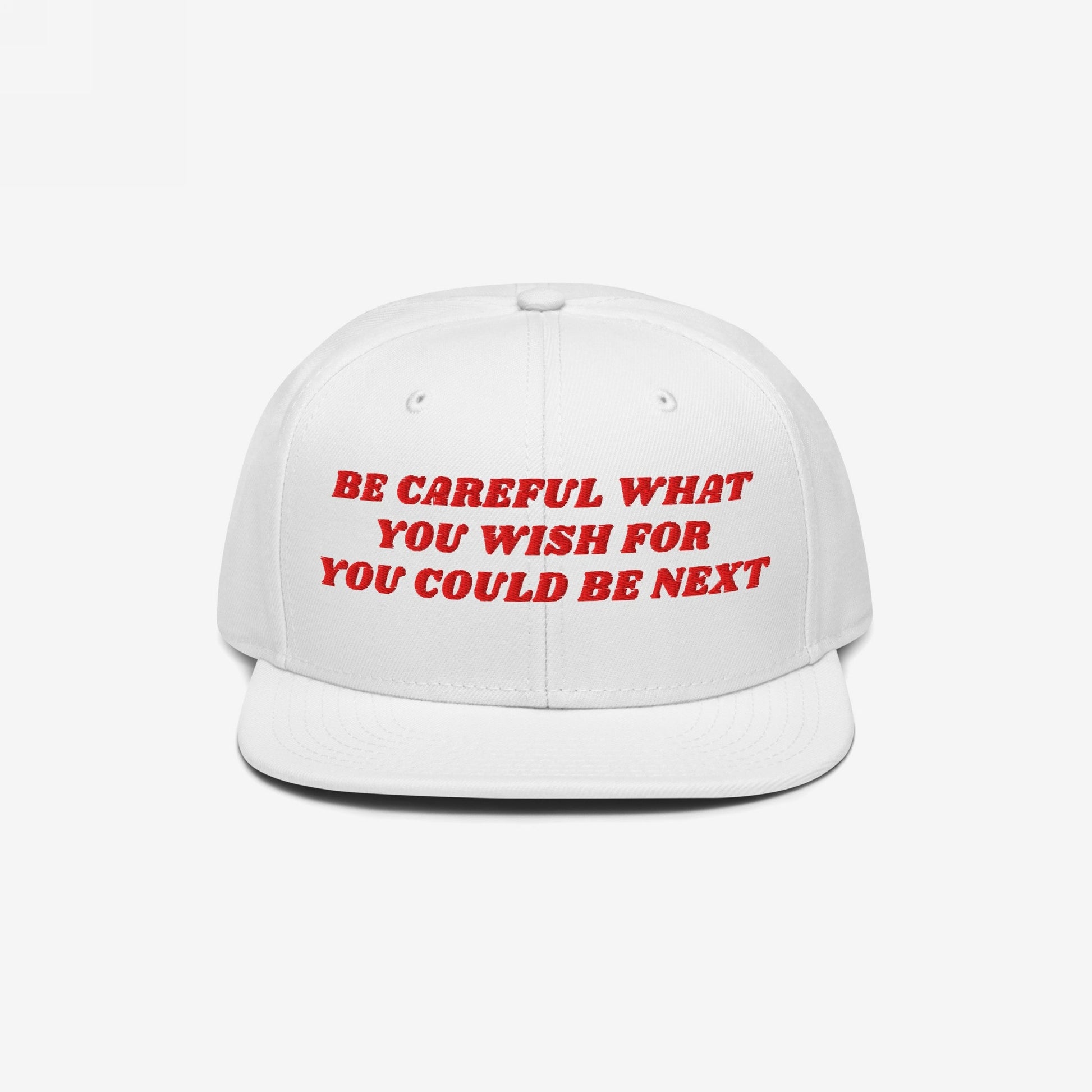 The Be Careful Hat features bold red embroidery reading, BE CAREFUL WHAT YOU WISH FOR YOU COULD BE NEXT, on a white snapback, embodying a powerful, unapologetic statement against extremism.
