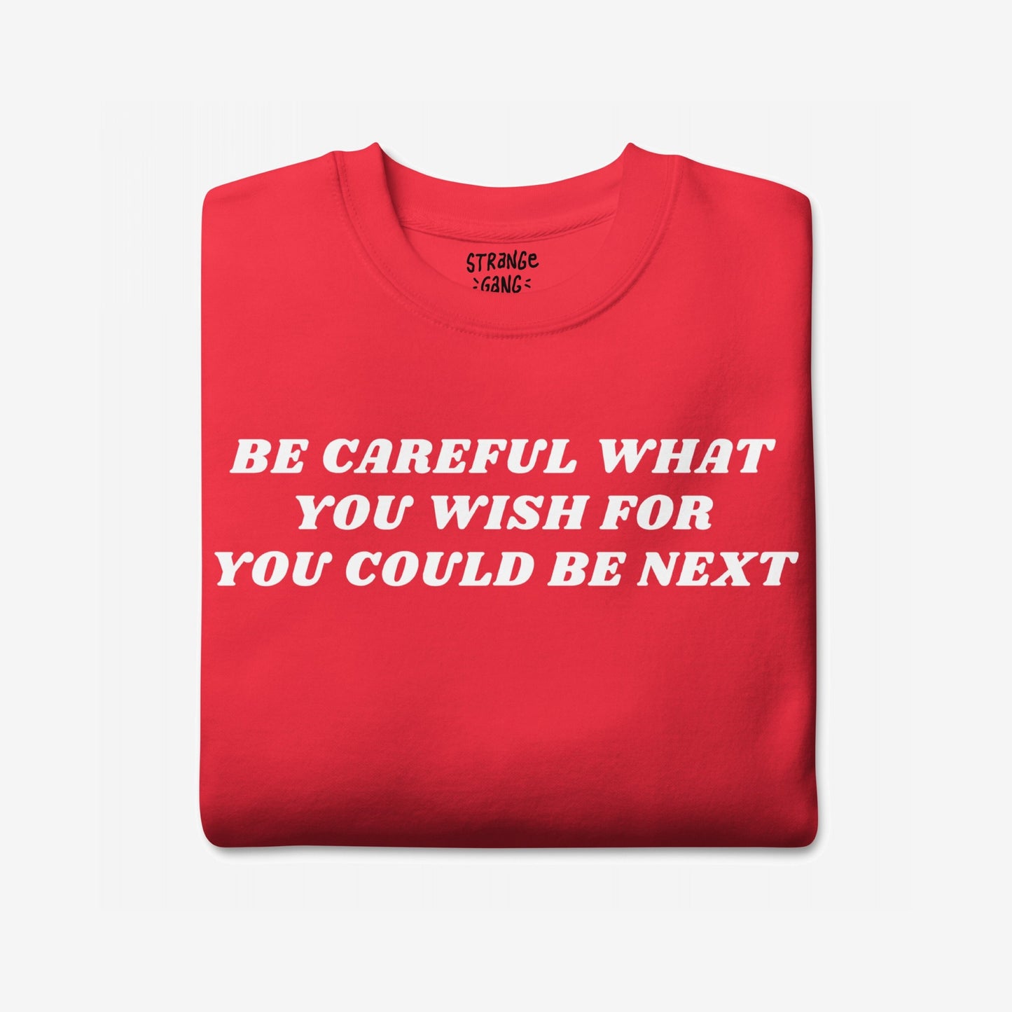 The Be Careful Sweatshirt EU displays bold white text warning BE CAREFUL WHAT YOU WISH FOR YOU COULD BE NEXT on a folded red garment, embodying activism and resistance.