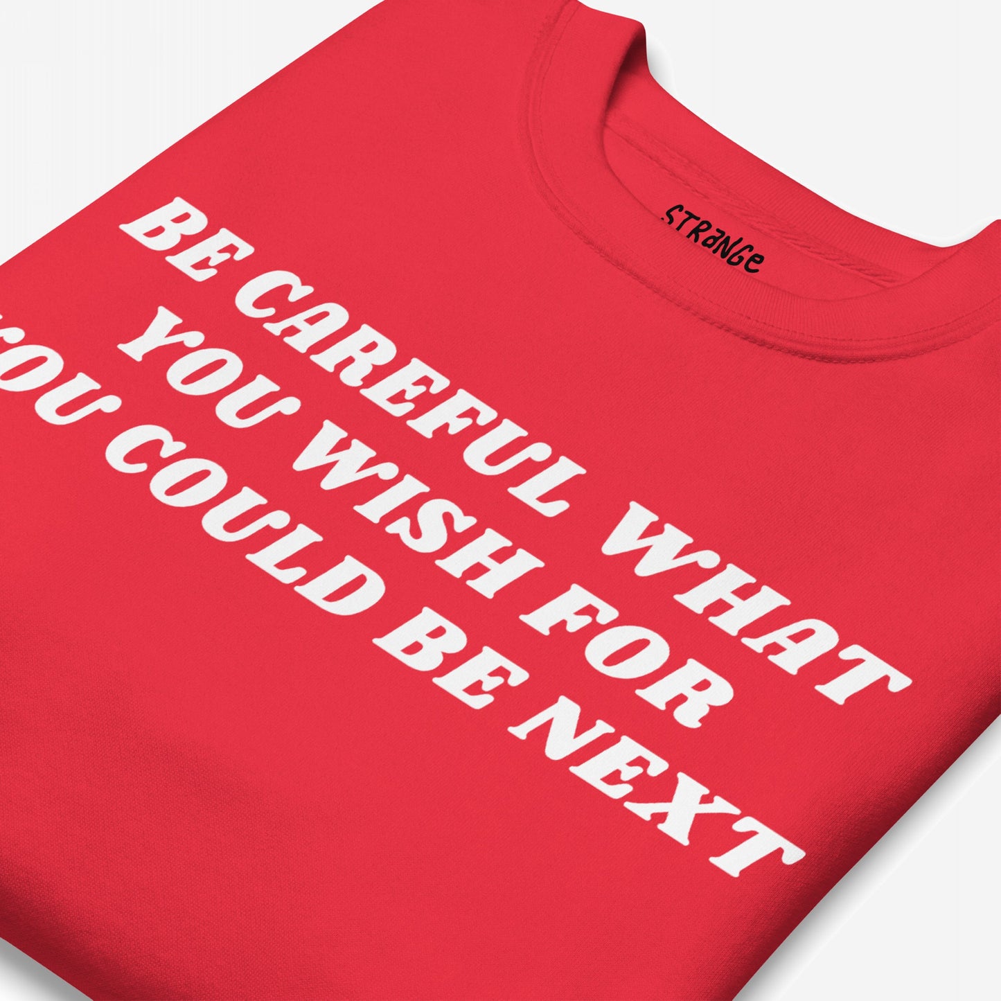 Be Careful Sweatshirt EU: A folded red crew-neck with bold white block lettering, delivering a strong anti-fascist message. Ideal for activists, aligning with Egoproof's powerful statement apparel.