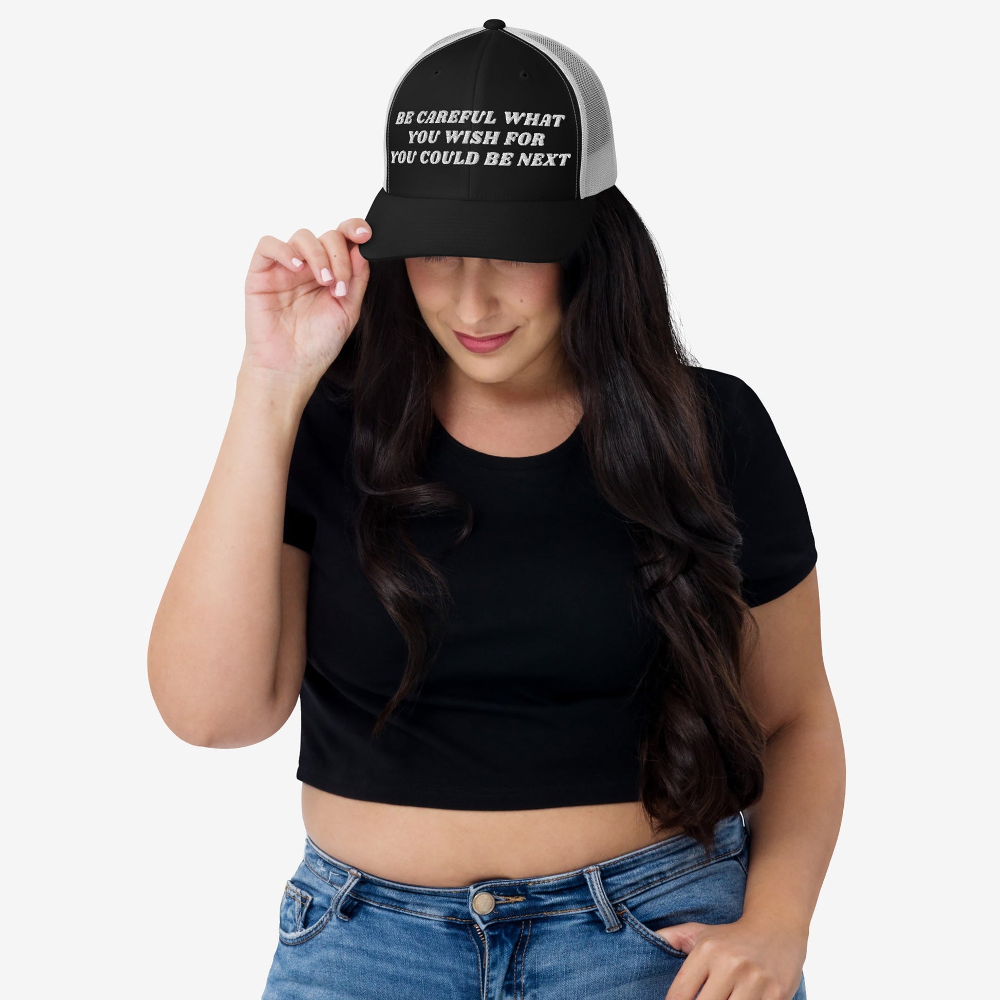 Woman wearing the Be Careful Hat, a black-and-white mesh trucker style with bold embroidered text promoting progressive ideals. Perfect for making a powerful statement on everyday occasions.
