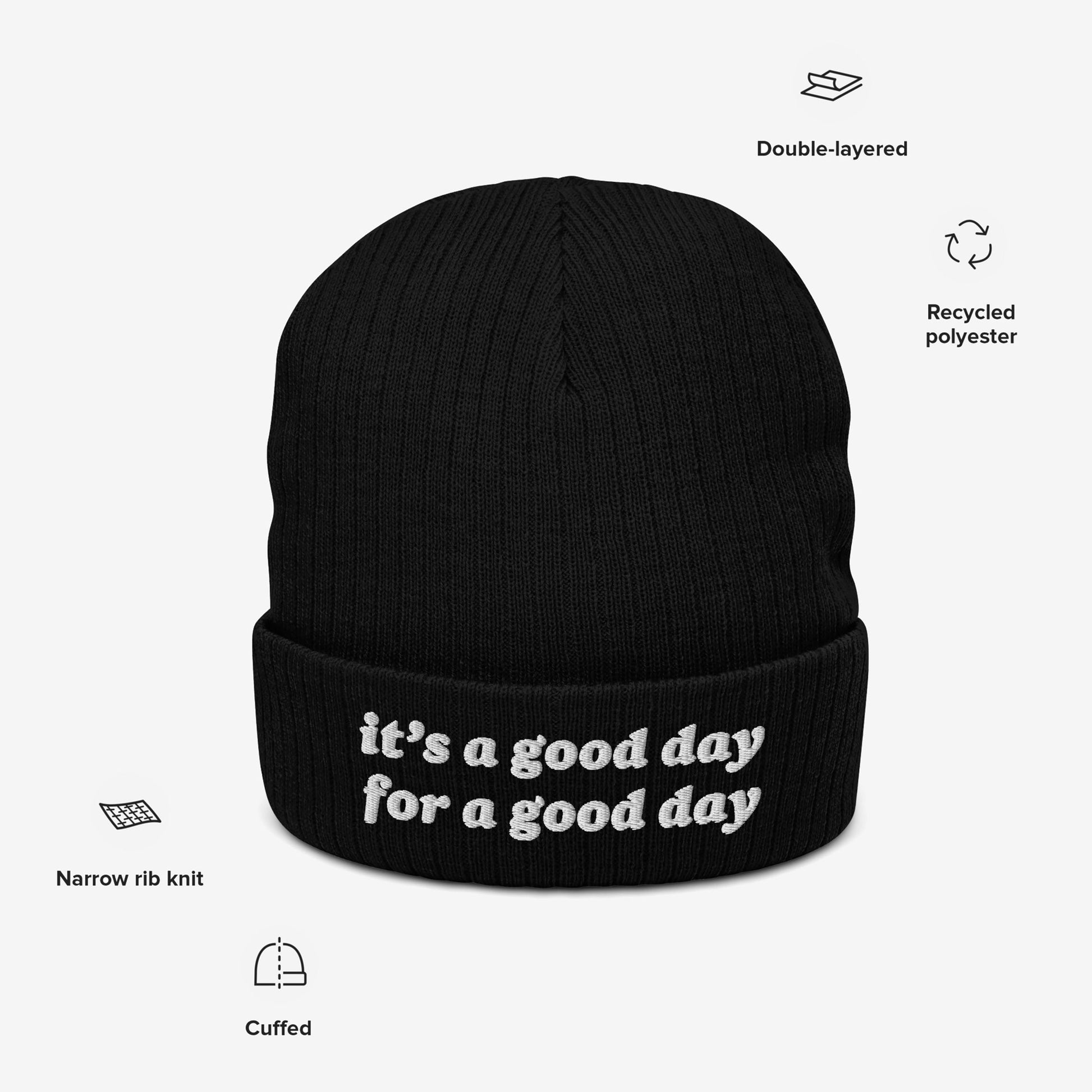 The Good Day Hat, a black cuffed knit beanie, features a narrow-rib texture and the uplifting slogan “it’s a good day for a good day,” promoting positivity and mental health advocacy.