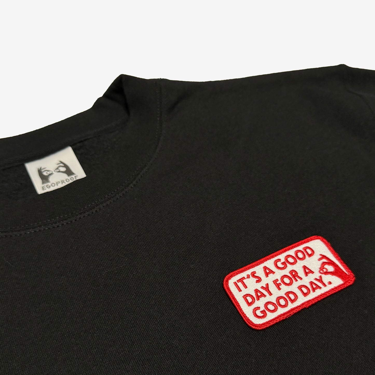 Good Day Sweatshirt by EGOPROOF features a small embroidered patch on the left chest with a motivational message, embodying subtle encouragement for those navigating daily mental health challenges.