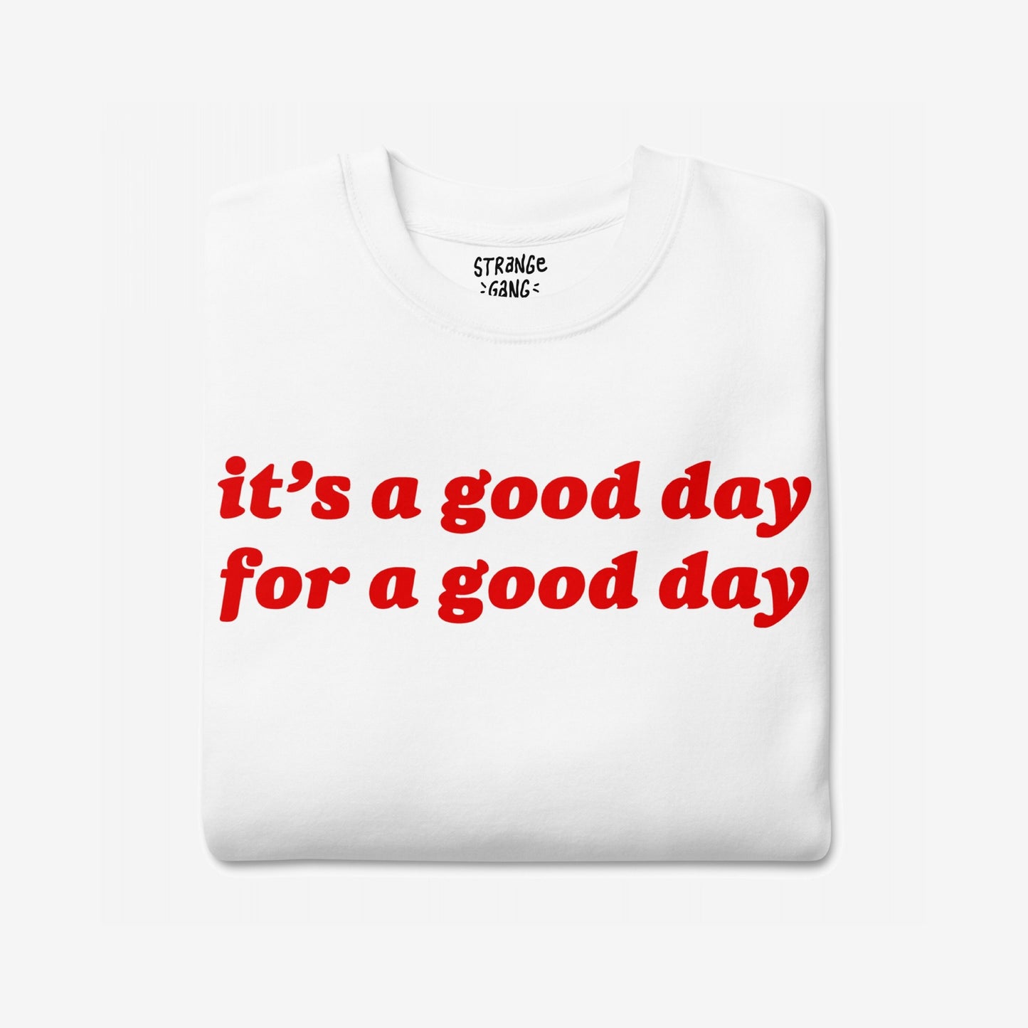 Good Day Sweatshirt EU features a bold red slogan, it’s a good day for a good day, on a neatly folded white T-shirt, symbolizing optimism and comfort, ideal for gifting or personal inspiration.