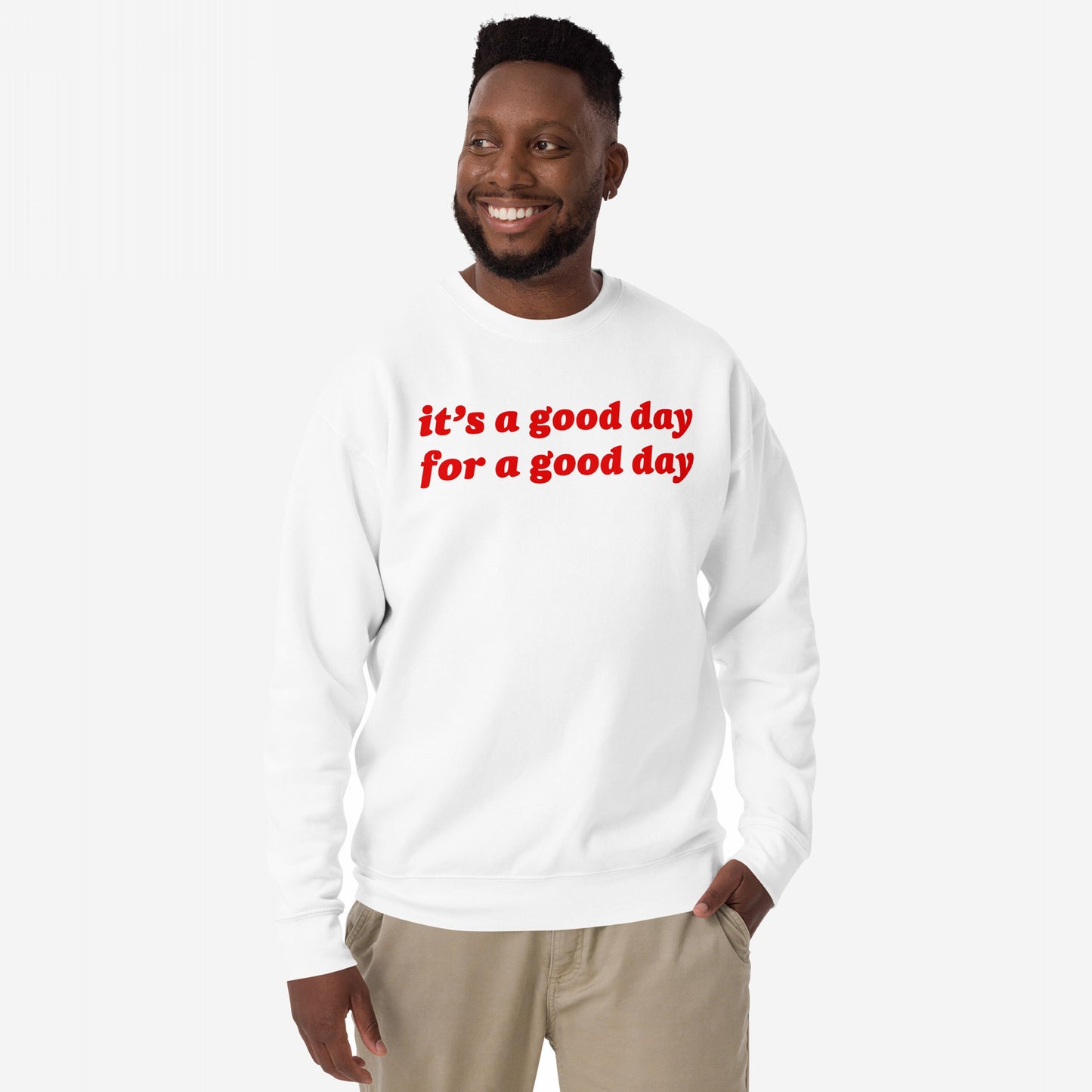 Smiling man wearing the Good Day Sweatshirt EU with bold red lettering, embodying comfort and optimism. Ideal for those embracing positivity and mental health awareness. Perfect for gifting or inspiring daily.