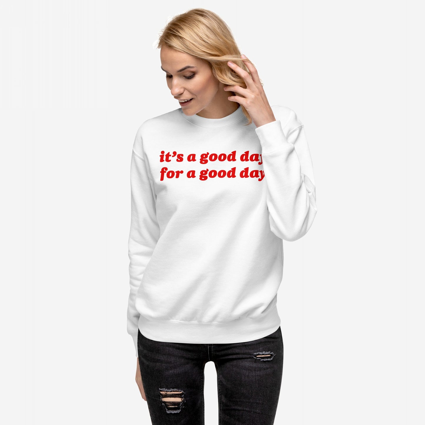 Young woman wearing the Good Day Sweatshirt EU, displaying the phrase “it’s a good day for a good day” in bold red. Paired with black jeans, emphasizing comfort and optimism.