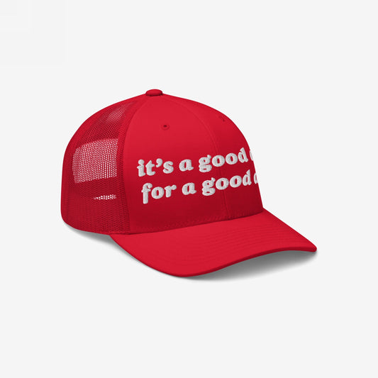 Red trucker-style Good Day Hat featuring white embroidered lowercase text, it’s a good day for a good day, on front panels, with red mesh back for ventilation, embodying positive vibes.