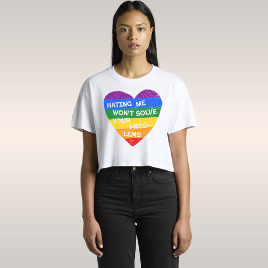 Woman wearing No LGBTQ Hate Women's Baby Tee black crop top with rainbow heart and slogan Hating Me Won't Solve Your Problems