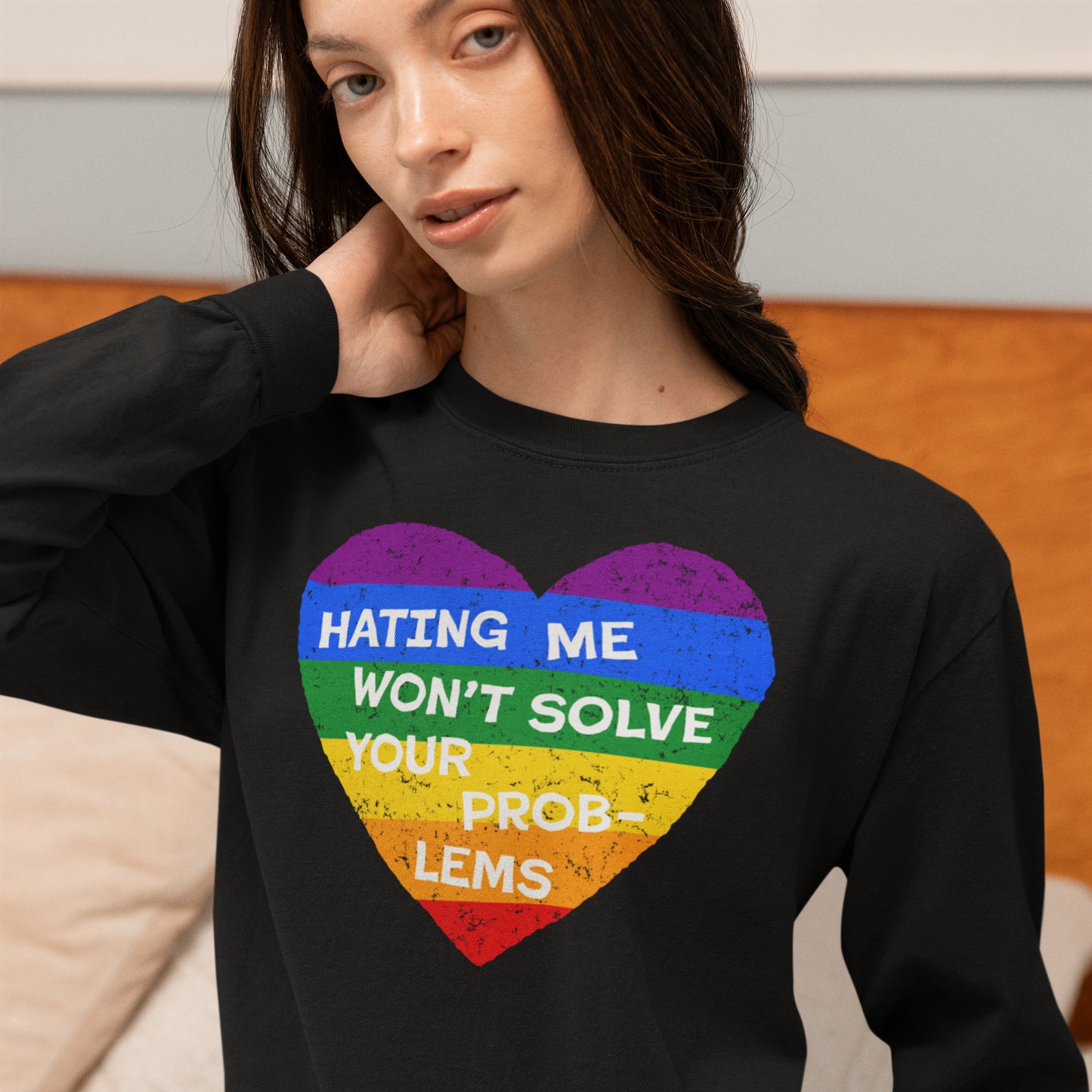 Woman wearing No LGBTQ Hate Long Sleeve T-shirt with rainbow heart and message Hating Me Won’t Solve Your Problems.