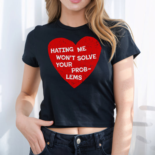 Woman wearing a black No Hate Women's Baby Tee with a red heart and message Hating Me Won't Solve Your Problems cut to fit style.