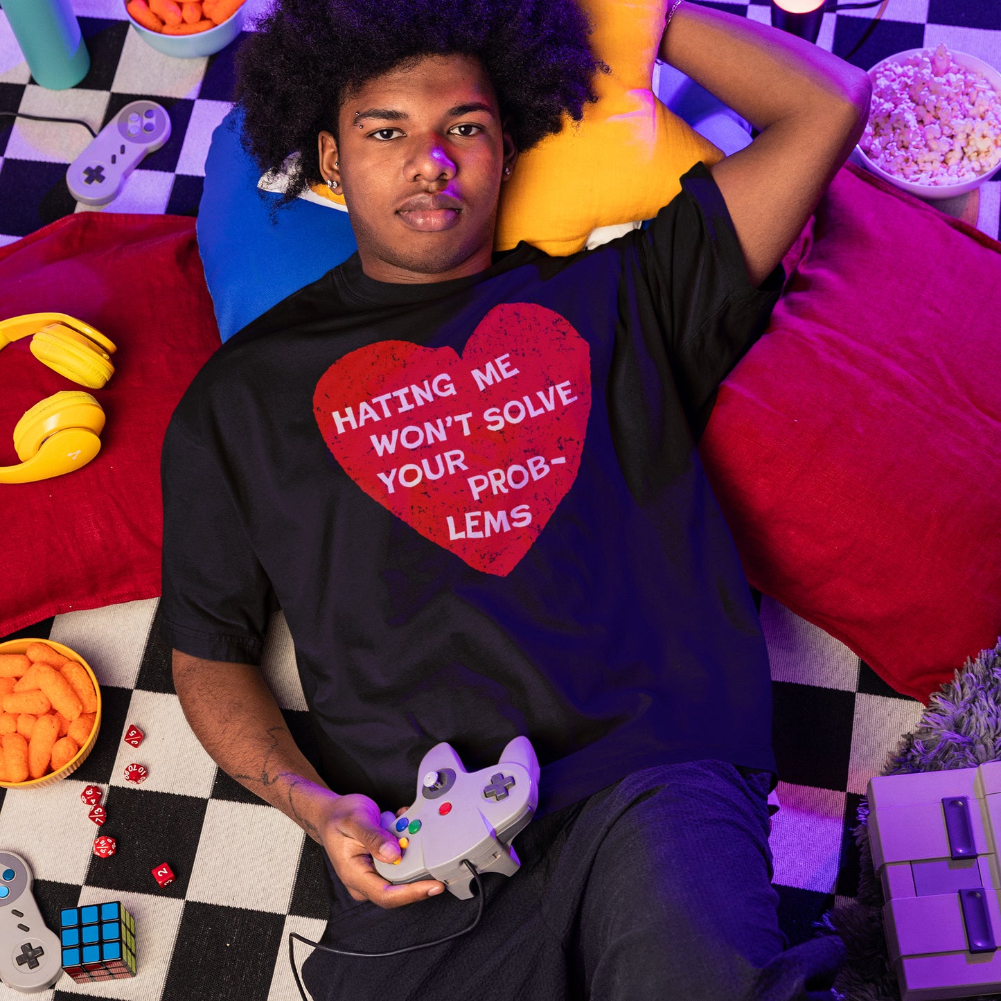 Young person wearing No Hate T-shirt with "Hating Me Won't Solve Your Problems" heart design, holding a game controller.