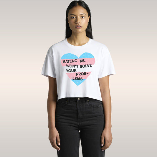 No Trans Hate Women's Baby Tee with trans pride heart design and bold message "Hating Me Won't Solve Your Problems" on black