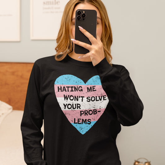 Woman wearing No Trans Hate Long Sleeve T-shirt with heart and message Hating Me Won't Solve Your Problems in trans pride colors.