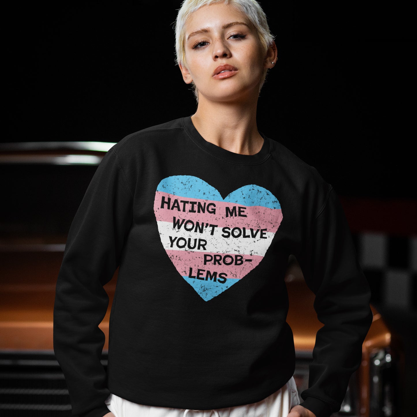 Person wearing black No Trans Hate Hoodie & Sweatshirt with trans flag heart and message "Hating Me Won't Solve Your Problems