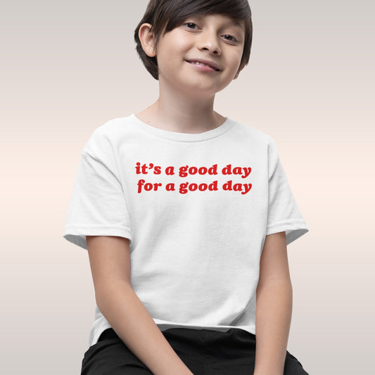 Child wearing the Good Day Kids T-shirt EU featuring the uplifting message “it’s a good day for a good day” in bold red