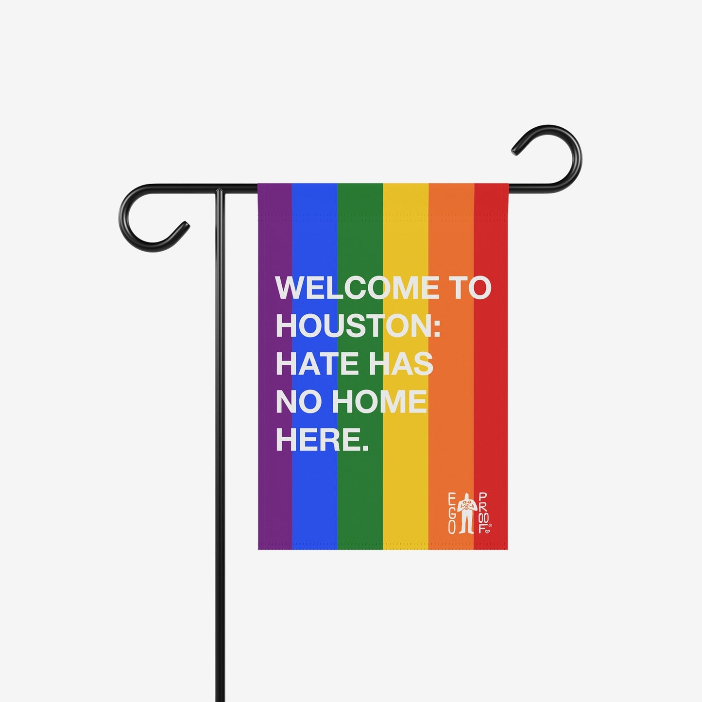 Custom Hate Has No Home Here Pride Garden Flag displayed on a black metal stand, featuring rainbow stripes and a welcoming message promoting inclusion and acceptance, ideal for diverse and supportive outdoor spaces.