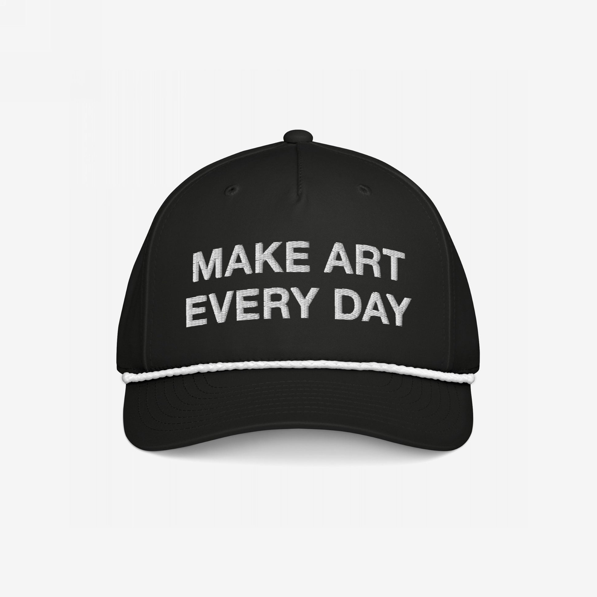 Make Art Every Day Hat featuring a black trucker-style design with white embroidery, braided rope detail above the brim, and adjustable back. A wearable mantra motivating creativity and resilience.
