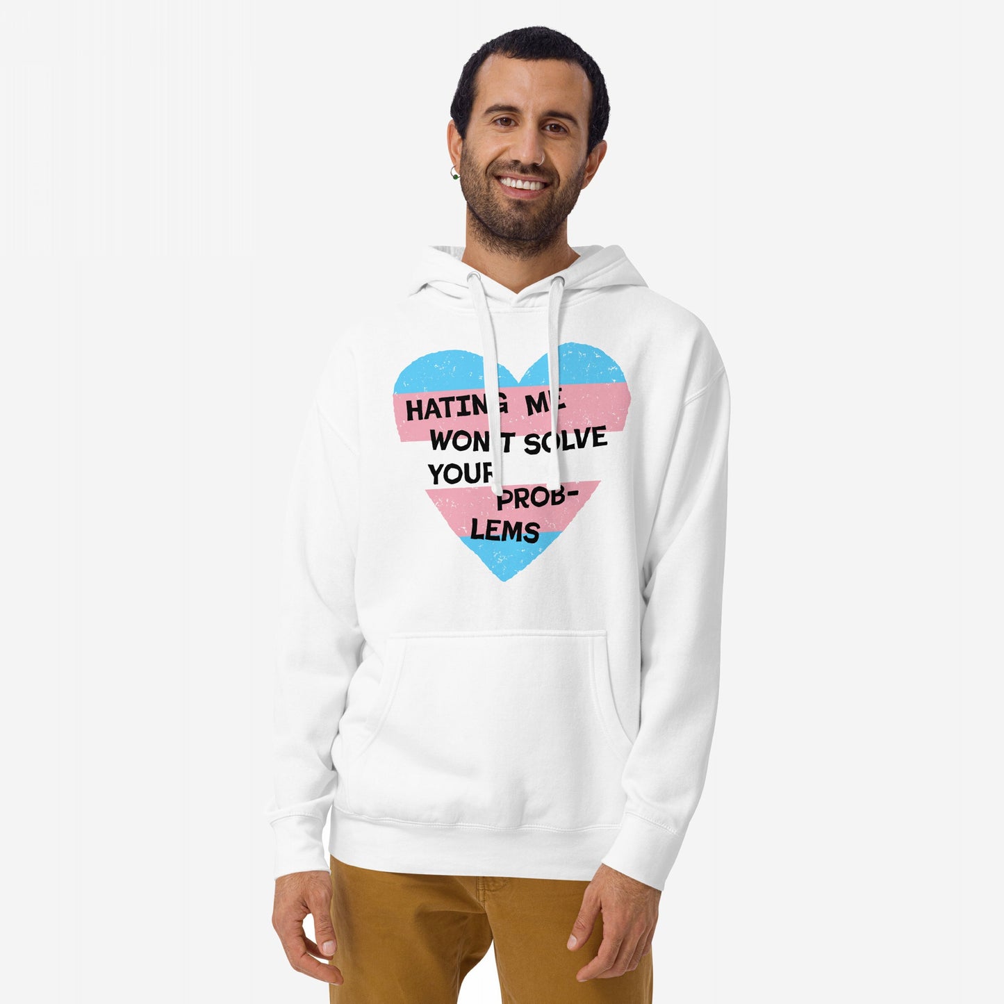 Smiling man in a No Trans Hate Hoodie EU with trans-pride heart graphic and slogan, embodying resistance. He stands confidently, hands at sides, against a plain background, reflecting Egoproof's empowering ethos.