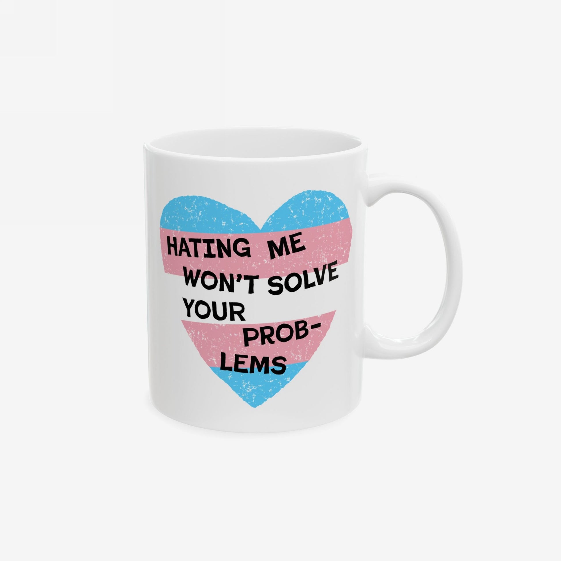 No Trans Hate Mug featuring a pastel-striped heart and “Hating Me Won’t Solve Your Problems” quote, showcasing pride and empowerment. Ceramic, microwave, and dishwasher safe, with a standard C-handle.
