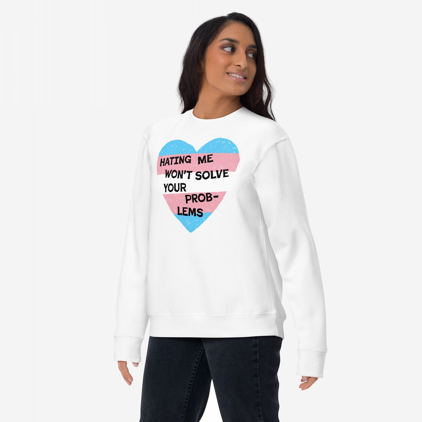 The No Trans Hate Sweatshirt EU features a young woman wearing a white sweatshirt with a distressed heart graphic in blue and pink stripes, showcasing the empowering message, Hating Me Won’t Solve Your Problems.