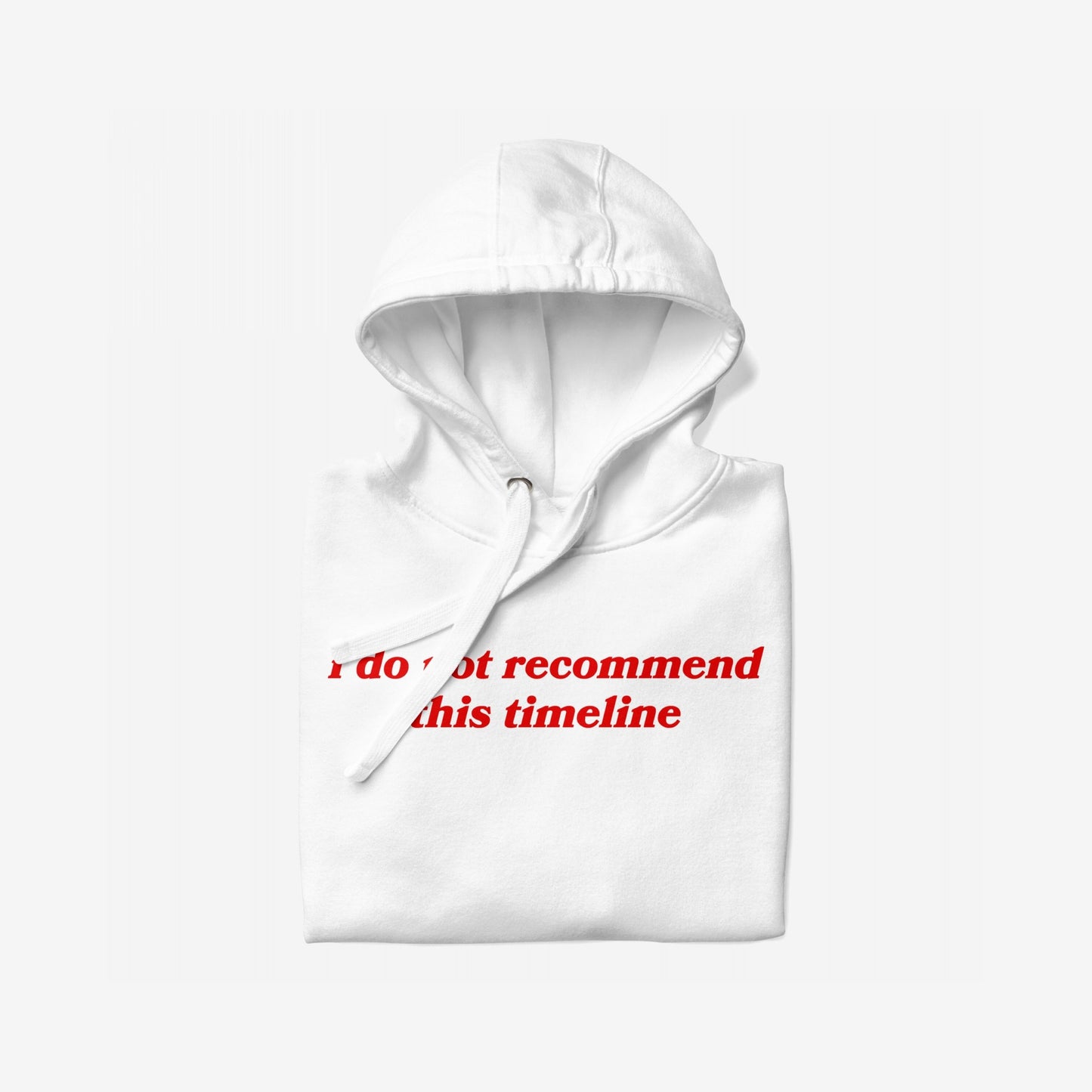 Timeline Hoodie EU: A folded white hoodie featuring bold red serif-style text I do not recommend this timeline on the front, embodying a statement piece for navigating life's absurdities.