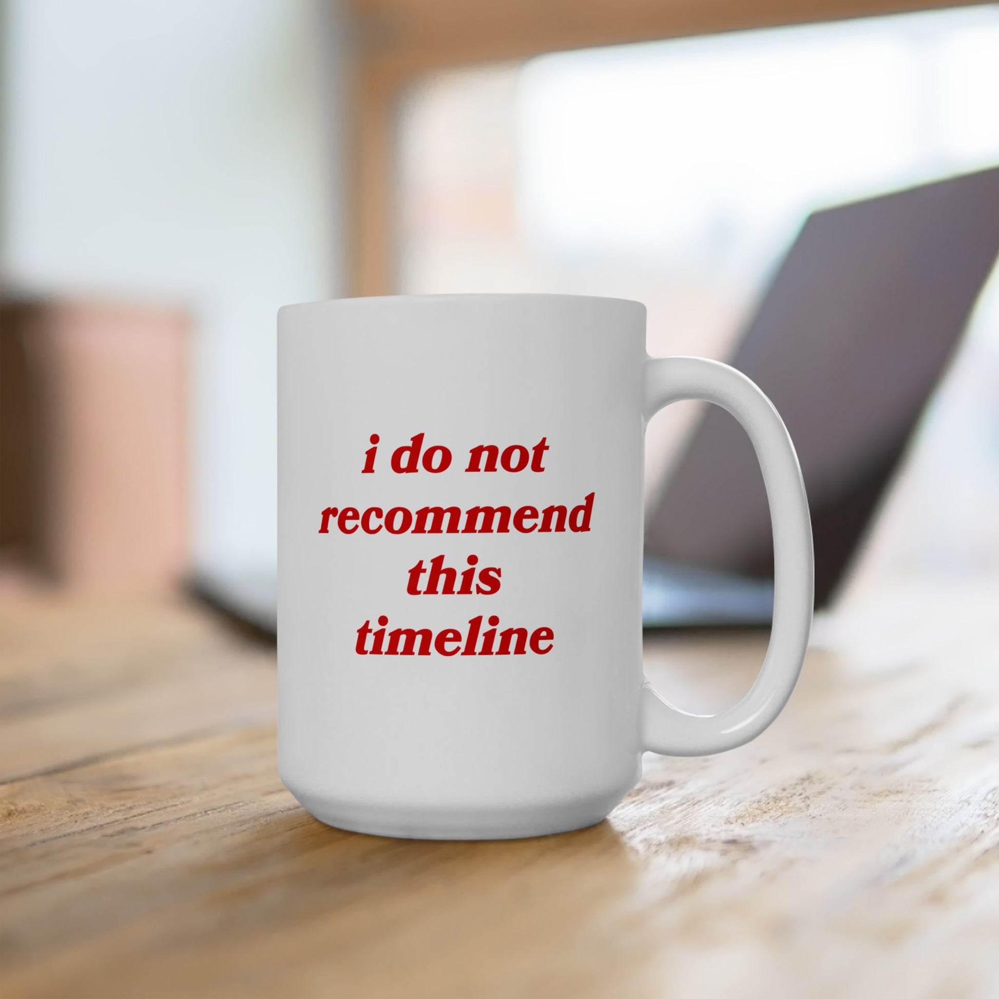 Timeline Mug on a wooden desk, featuring red text: “i do not recommend this timeline.” Ideal for those navigating chaos with humor, reflecting Egoproof's focus on mental health and societal commentary.