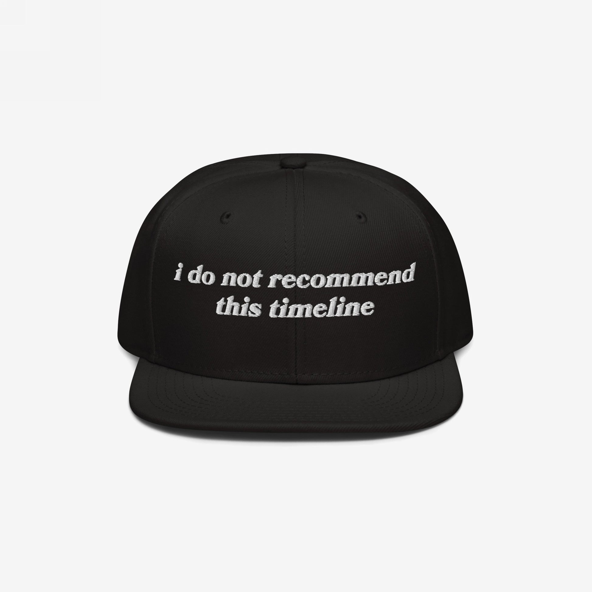 Black snapback cap with white embroidery reading I Do Not Recommend This Timeline, symbolizing modern chaos. Ideal for irony enthusiasts, available in various styles. Proceeds support NAMI.