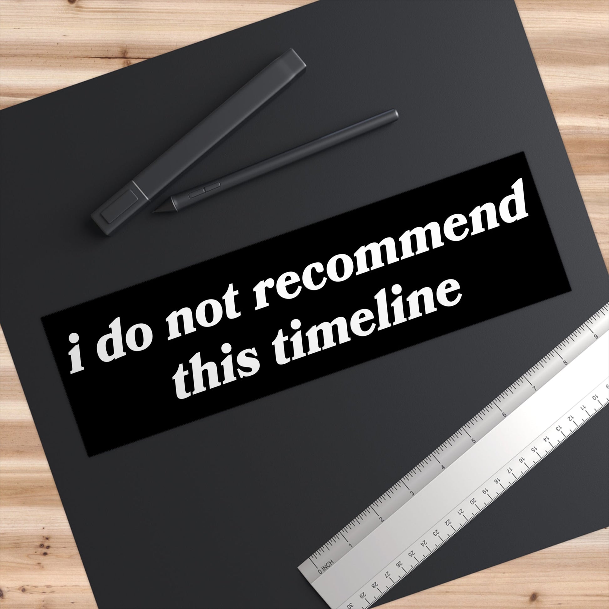 Timeline Sticker & Magnet on a black drawing surface with two styluses and a ruler, featuring bold text I do not recommend this timeline. Perfect for cars, laptops, or personal reflections.