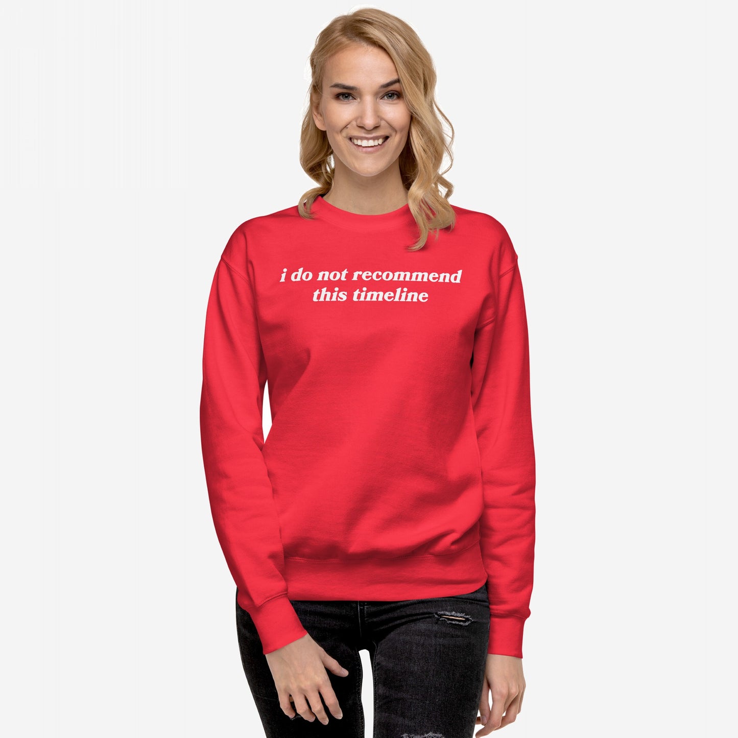 Woman in a bright red Timeline Sweatshirt EU with the phrase i do not recommend this timeline, symbolizing sarcasm and burnout. She smiles confidently, embodying Egoproof's mission of making powerful, relatable statements.