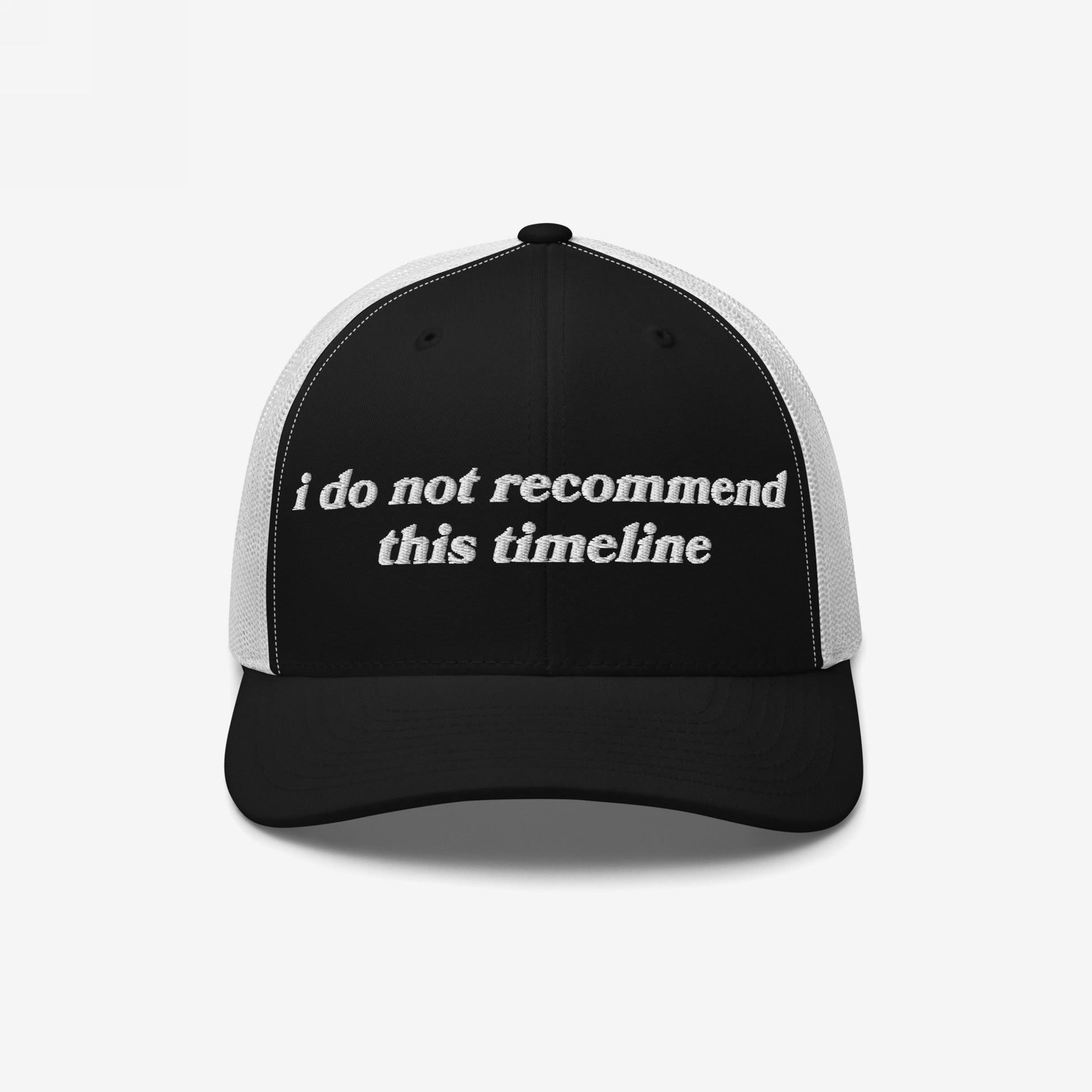 Black-and-white trucker cap with white mesh back. I Do Not Recommend This Timeline embroidered on front, merging retro style with modern sarcasm for those navigating chaos with irony.