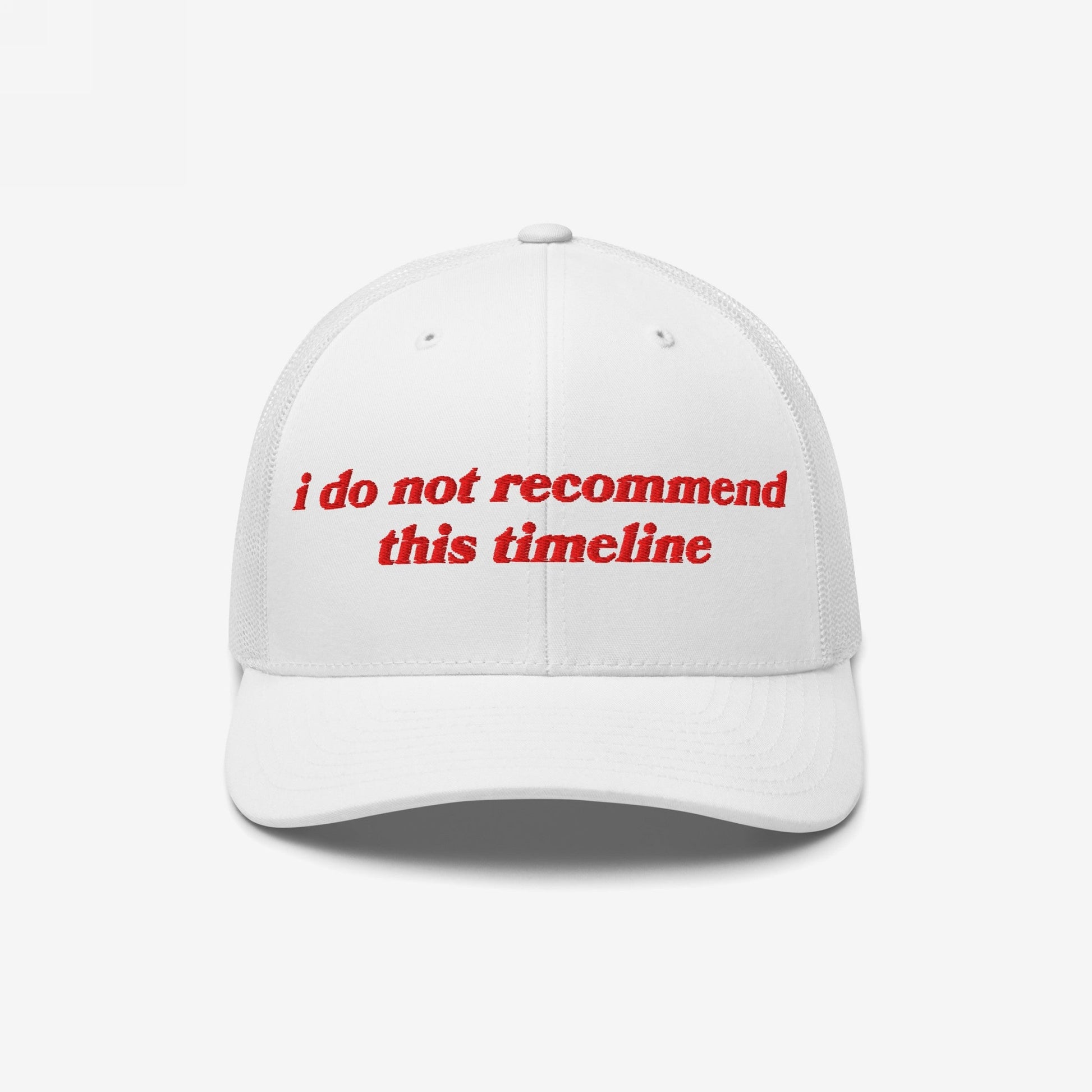 White mesh-back trucker cap with a curved brim featuring bold red embroidery: “I Do Not Recommend This Timeline.” A statement piece for navigating chaos with irony and style.